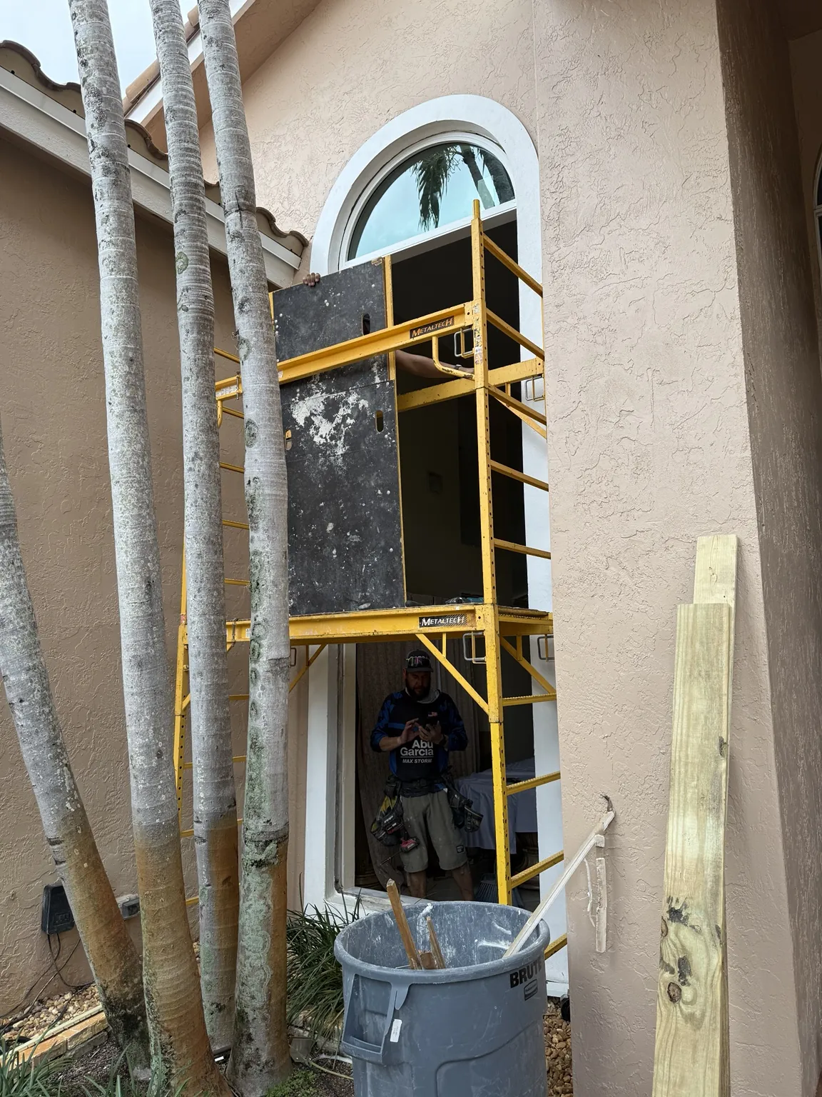 Scaffold installation work on a tall arched impact window
