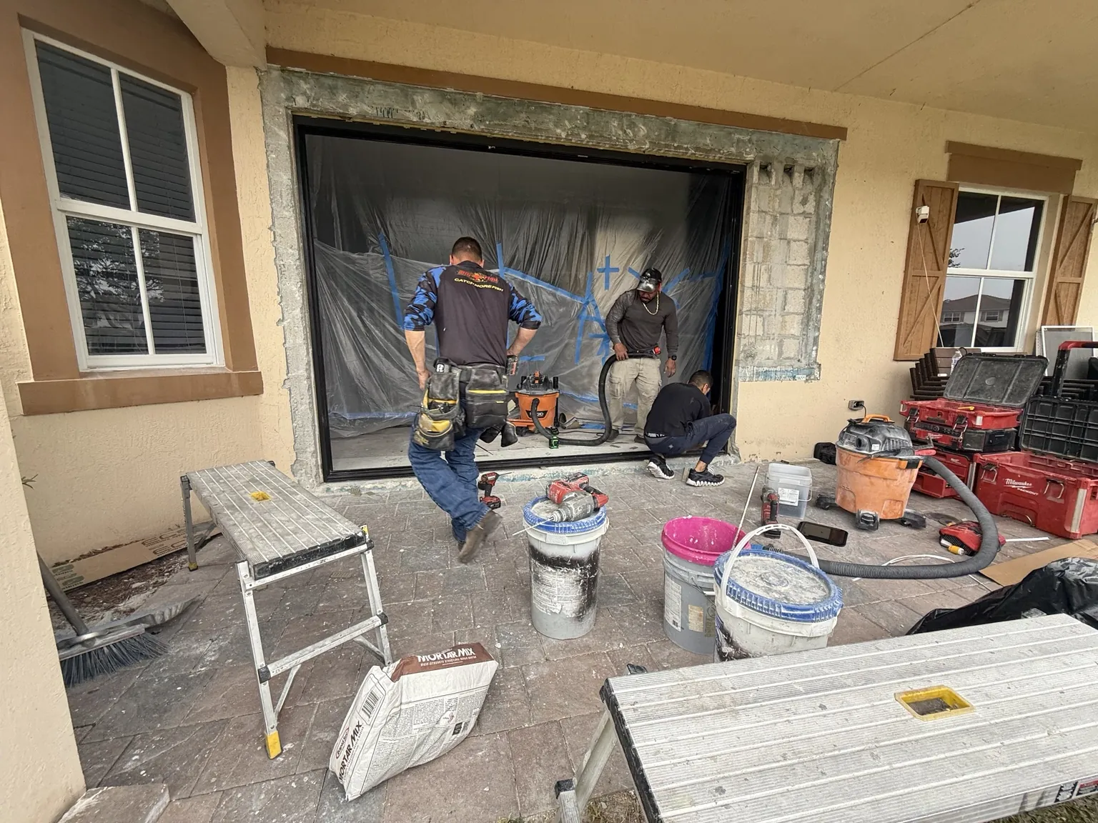 Installation crew preparing a large impact door opening